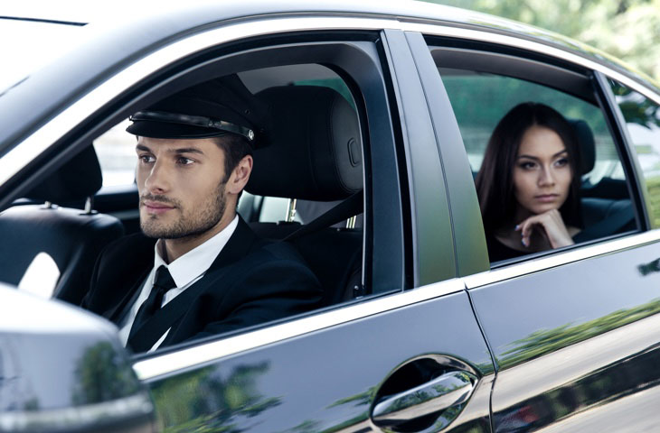 Véhicule de luxe avec chauffeur en costume et jeune femme à l'arrière